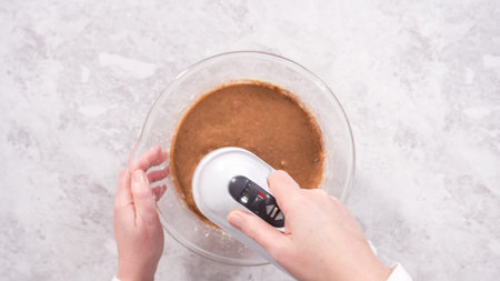 Flat lay. Step by step. Mixing ingredients in a glass mixing bowl to prepare red velvet bundt cake.