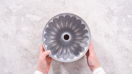 flat lay. step by step. Greasing bundt cake pan with vegetable shortening and sprinkling with white...