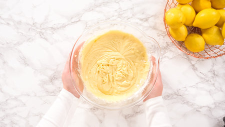 Flat lay. Step by step. Mixing ingredients in a glass mixing bowl to prepare lemon bundt cake.
