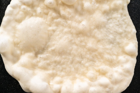 Preparing homemade flatbread on a cast-iron skillet.の写真素材