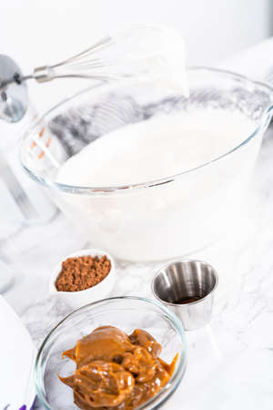 Mixing ingredients in a glass mixing bowl to make chocolate ice cream.の写真素材