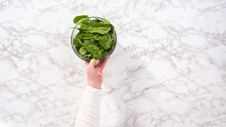 flat lay. step by step. Ingredients in glass mixing bowls to prepare spinach and ham frittata.の写真素材