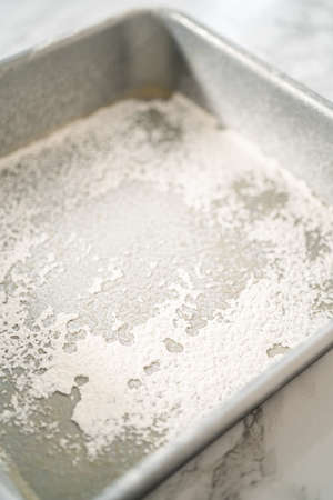 Greasing metal square baking pan to bake sweets.の写真素材