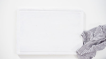 flat lay. step by step. Empty white cutting board with a kitchen towel.の写真素材