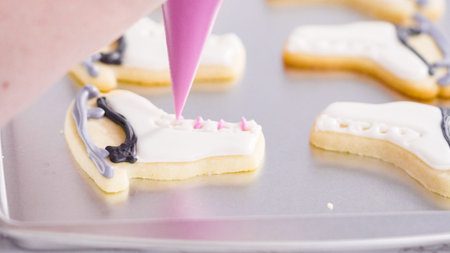 Icing figure skate shaped sugar cookies with royal icing.