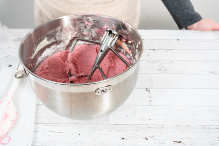 Preparing raspberry cream cheese buttercream in kitchen mixer for bake chocolate raspberry cupcakes.