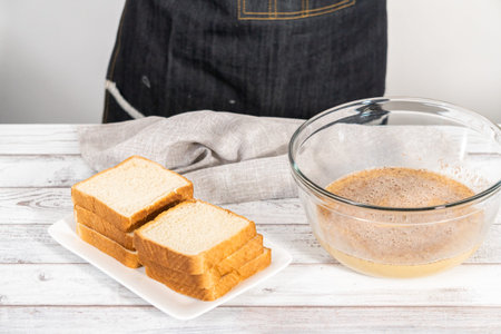 Stack of texas toast on a white plate, ready to prepare french toast.