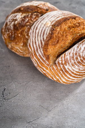 Freshly baked loaf of a wheat sourdough bread with marks from bread proofing basket.