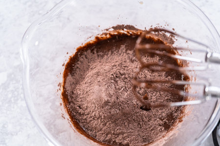Mixing ingredients to bake unicorn rainbow chocolate cupcakes.