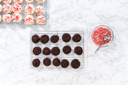 flat lay. Dipping chocolate cookies into the melted white chocolate to prepare peppermint white...