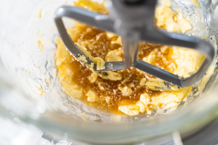 Mixing ingredients in a kitchen stand mixer to bake soft oatmeal raisin walnut cookies.
