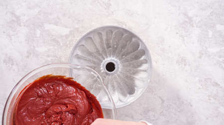 Flat lay. Step by step. Pouring cake batter into a bundt cake pan to bake a red velvet bundt cake.の写真素材