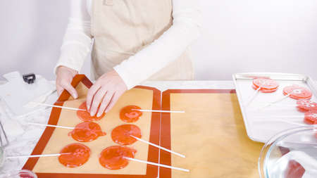 Step by step. Peeling cooled homemade lollipops from silicone baking mats.の写真素材