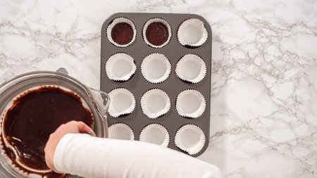Flat lay. Step by step. Baking chocolate cupcakes. Scooping chocolate cupcake batter into a cupcake pan.の写真素材