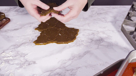 Step by step. Cutting out shapes with Christmas cookies cutter from gingerbread cookie dough.