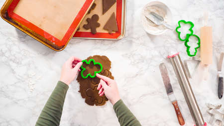 Flat lay. Step by step. Cutting out shapes with Christmas cookies cutter from gingerbread cookie dough.の写真素材