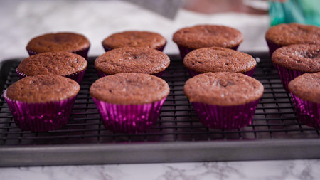 Step by step. Cooling red velvet cupcakes on a kitchen drying rack.の写真素材