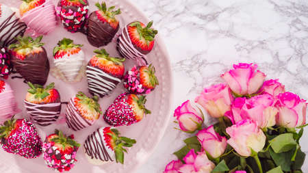 Flat lay. Step by step. Variety of chocolate dipped strawberries on a pink cake stand.の写真素材