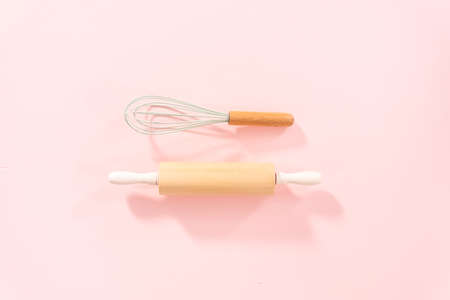 Flat lay. New blue silicone kitchen utensils with wooden handles on a pink background.の写真素材