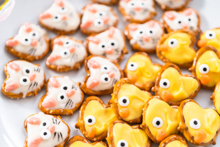 Easter chocolate-covered pretzel bunnies and ducklings on a white serving plate for the Easter...