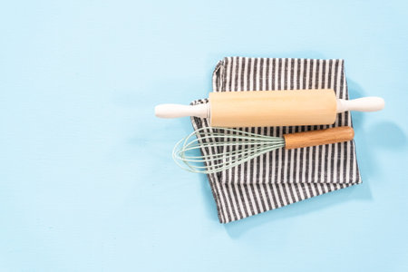 Flat lay. New blue silicone kitchen utensils with wooden handles on a blue background.