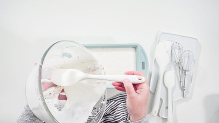 Flat lay. Pouring ice cream mixture into the baking pan to be frozen.