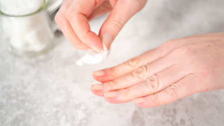 Woman finishing her manicure at home with simple manicure tools. Removing old nail polish from the nails.の写真素材