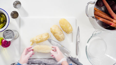 Flat lay. Step by step. Cutting cookies vegetables on a white cutting board for vinaigrette salad.の写真素材