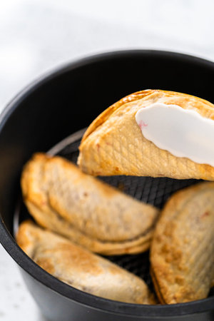 Frying sweet cherry empanadas in the air fryer.