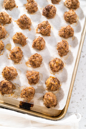 Cooling homemade oven-baked meatballs on the kitchen counter.の写真素材