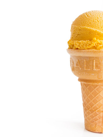 Scoop of gourmet pumpkin gelato in cake cone on white background.