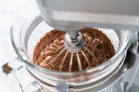 Whipping chocolate ganache with an electric kitchen mixer.