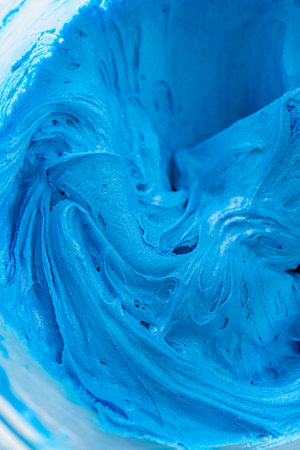 Mixing food coloring into the buttercream frosting to decorate American flag mini cupcakes.の写真素材