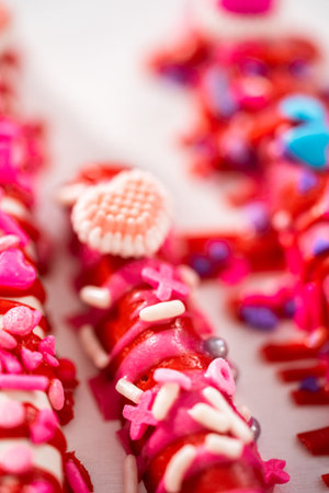 Chocolate-covered pretzel rods decorated with heart-shaped sprinkles for Valentines Day.の写真素材