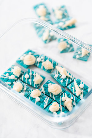 Packaging mini mermaid chocolate bars into a food glass container for storage.の写真素材