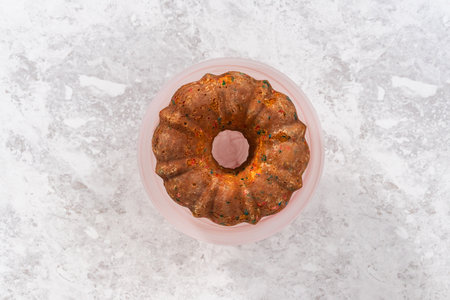 Flat lay. Funfettti bundt cake prepared for frosting on a cake stand.の写真素材