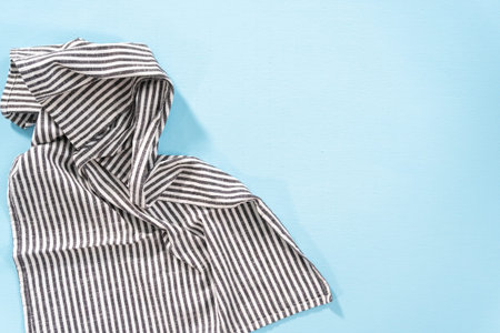 Flat lay. Black and white kitchen towel on a blue background.