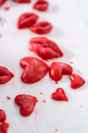 Dusting chocolate lips and heart-shaped chocolates with editable glitter for Valentines Day.