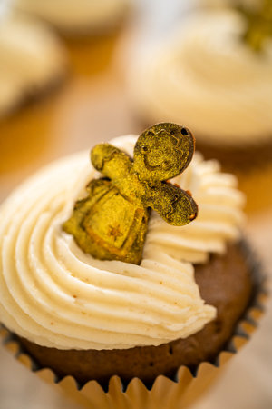 Freshly baked gingerbread cupcakes with eggnog buttercream frosting and topped with a gingerbread man.の写真素材