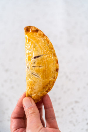 Freshly baked sweet empanadas with blueberries on the kitchen counter.