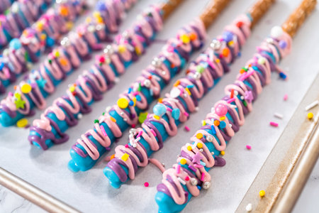 Mermaid chocolate pretzel rods drizzled with pink and purple chocolate and covered with sprinkles.の写真素材