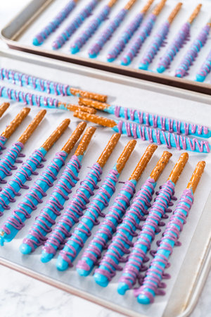 Drizzled with chocolate pretzel rods drying on a baking sheet lined with parchment paper.の写真素材