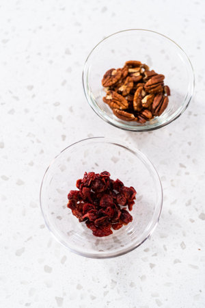 Measured ingredients in glass mixing bowls to make white chocolate cranberry pecan fudge.