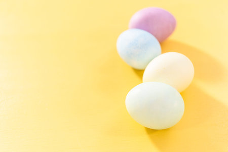 Colored hard-boiled eggs on a yellow background.