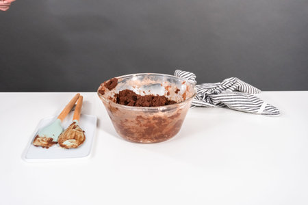 Mixing ingredients in a glass mixing bowl to bake chocolate cookies.