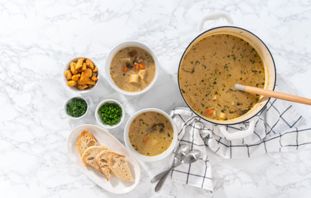Flat lay. Serving creamy wild mushroom soup made out of dehydrated wild mushrooms in white bowls...