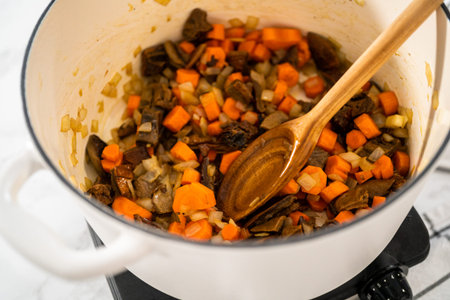 Cooking creamy wild mushroom soup made in an enameled dutch oven.