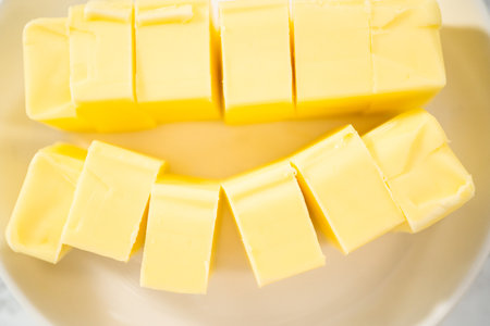 Measured ingredients in glass mixing bowls to make eggnog buttercream frosting.の写真素材