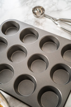 Lining cupcake pan with foil cupcake liners to bake gingerbread cupcakes.の写真素材