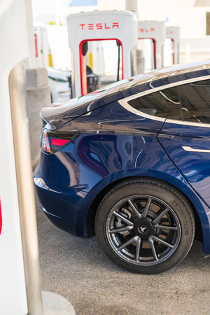 Baker, California, USA-October 12, 2021 - Tesla supercharging station during the day.のeditorial素材